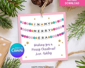 May include: Pink printable gift tag with a candy cane garland that spells "In My Merry Era". The tag has gold stars and the text "Wishing you a Merry Christmas! Love. Ashley" and "Happi Prints Studio".