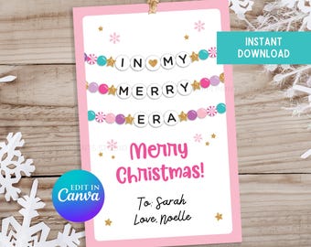 May include: A pink Christmas gift tag with the text "IN MY MERRY ERA" and "Merry Christmas!" in a festive font. The tag includes decorative stars and garlands. The tag is designed to be edited in Canva.