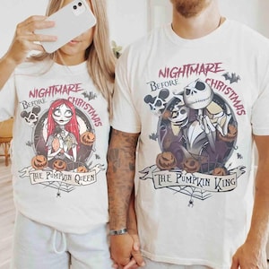 Puede incluir: Camisetas blanquecinas con un dise&ntilde;o gr&aacute;fico de "Pesadilla antes de Navidad". Una camiseta dice "The Pumpkin Queen" con Sally, calabazas y murci&eacute;lagos. La otra dice "The Pumpkin King" con Jack Skellington, calabazas y murci&eacute;lagos.