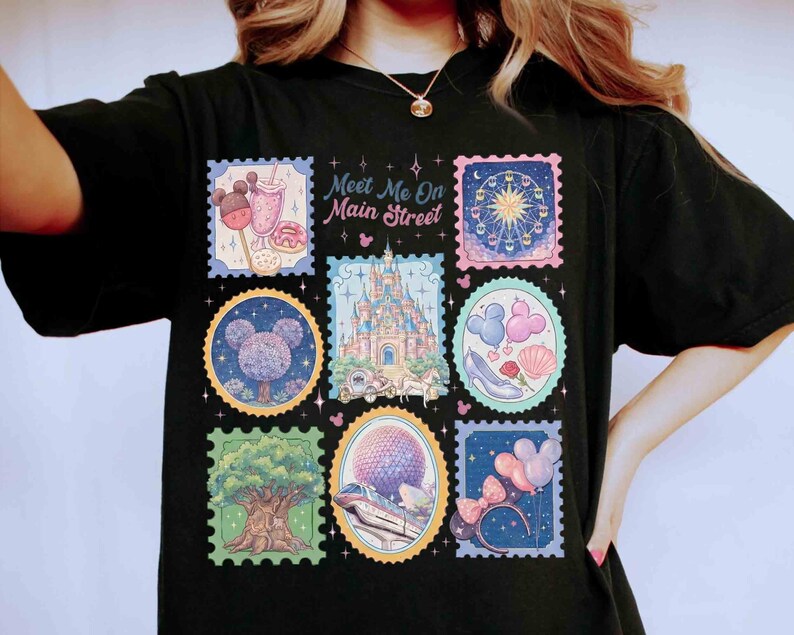 Peut inclure: T-shirt noir avec des motifs de timbres-poste color&eacute;s repr&eacute;sentant des images de parc &agrave; th&egrave;me. Les timbres incluent un ch&acirc;teau, une grande roue et Mickey Mouse. Le texte sur le t-shirt se lit "Meet Me On Main Street."