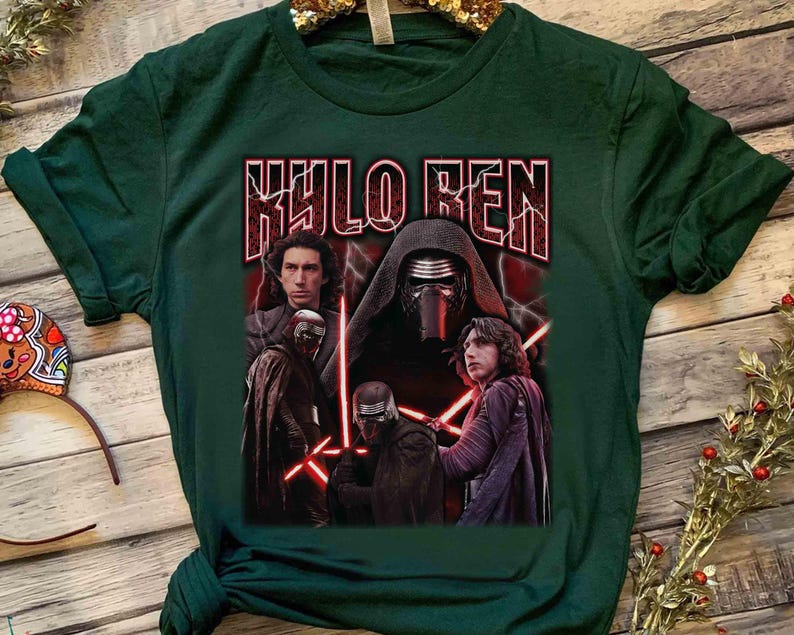 May include: Dark green t-shirt with a graphic of Kylo Ren from Star Wars. The design includes images of Kylo Ren with red lightsabers and the text "KYLO REN" in a bold, stylized font. The shirt is made of a soft material.