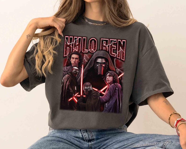May include: Dark grey t-shirt with a graphic of Kylo Ren from Star Wars. The design includes images of Kylo Ren and the text "KYLO REN" in a red, distressed font. The shirt has a vintage, worn appearance.