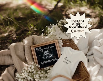 May include: A white onesie with the text "heaven sent" in black script. A framed ultrasound image with the text "baby myers" and "SEPTEMBER 2024" is in the background. The onesie and ultrasound image are in a wicker basket with white flowers.