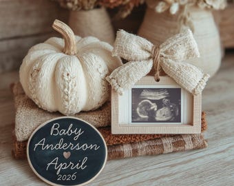 Peut inclure: Une citrouille en tricot crème est posée sur des couvertures pliées, à côté d'une image d'échographie encadrée ornée d'un nœud. Un panneau rond en tableau noir indique "Baby Anderson April 2026". L'image contient le texte "INSTANT DOWNLOAD".