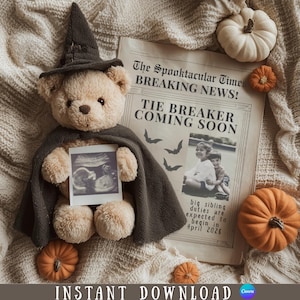 May include: A beige teddy bear wearing a witch hat and cape, holding an ultrasound photo. A newspaper with the headline "The Spooktacular Times" and the text "TIE BREAKER COMING SOON" is behind the bear. Small pumpkins surround the bear.