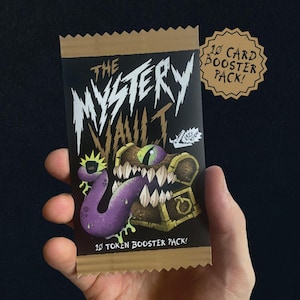 Op de afbeelding: Een rechthoekig kaart-boosterpakket met een zwarte achtergrond, de witte tekst The Mystery Vault en een afbeelding van een houten schatkist met een grote paarse tong, scherpe tanden en één groen oog. Er staat 10 Token Booster Pack op vermeld.