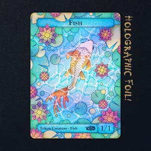 Könnte beinhalten: Eine rechteckige Spielkarte mit einem Koi-Fisch, der in blauem Wasser zwischen rosa und gelben Seerosen schwimmt. Der obere Text lautet Fish, der untere Text Token Creature - Fish 1/1. Die Karte hat eine holografische Folienbeschichtung.