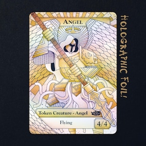 May include: A rectangular trading card featuring a holographic foil illustration of a winged angel in golden armour holding a long spear. The card displays the text ANGEL, Token Creature - Angel, Flying, and 4/4, with a sunburst design in the background.