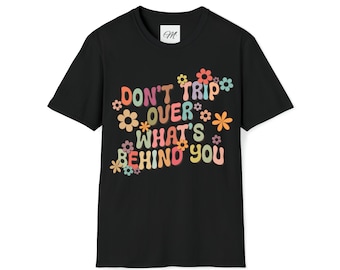 May include: Black t-shirt featuring a retro-style graphic that reads "Don't trip over what's behind you" with colourful flowers surrounding the text.
