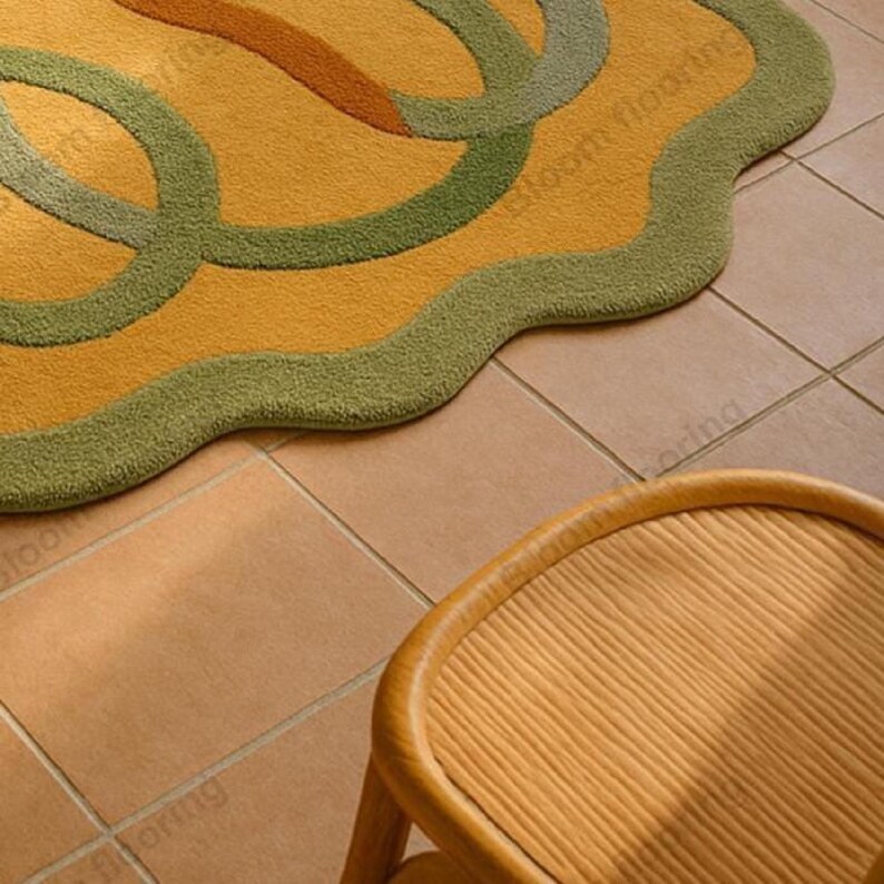 Hand tufted wool rug in mustard and green with abstract geometric loops; vintage-style bohemian area rug in a living room.
