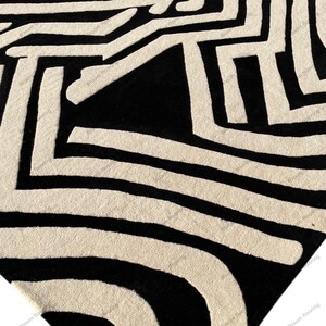 Scandinavian hand-tufted wool rug in black and white geometric pattern, plush minimalist decor for open space living room.