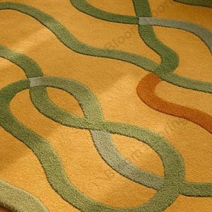 Hand tufted wool rug in mustard and green with abstract geometric loops; vintage-style bohemian area rug in a living room.