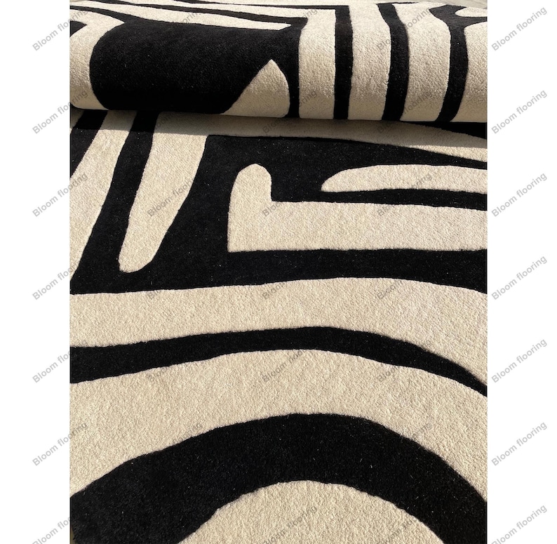 Scandinavian hand-tufted wool rug in black and white geometric pattern, plush minimalist decor for open space living room.
