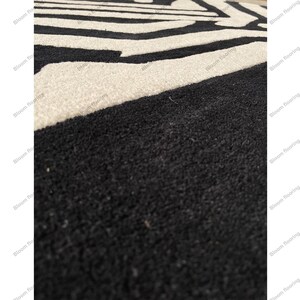 Scandinavian hand-tufted wool rug in black and white geometric pattern, plush minimalist decor for open space living room.