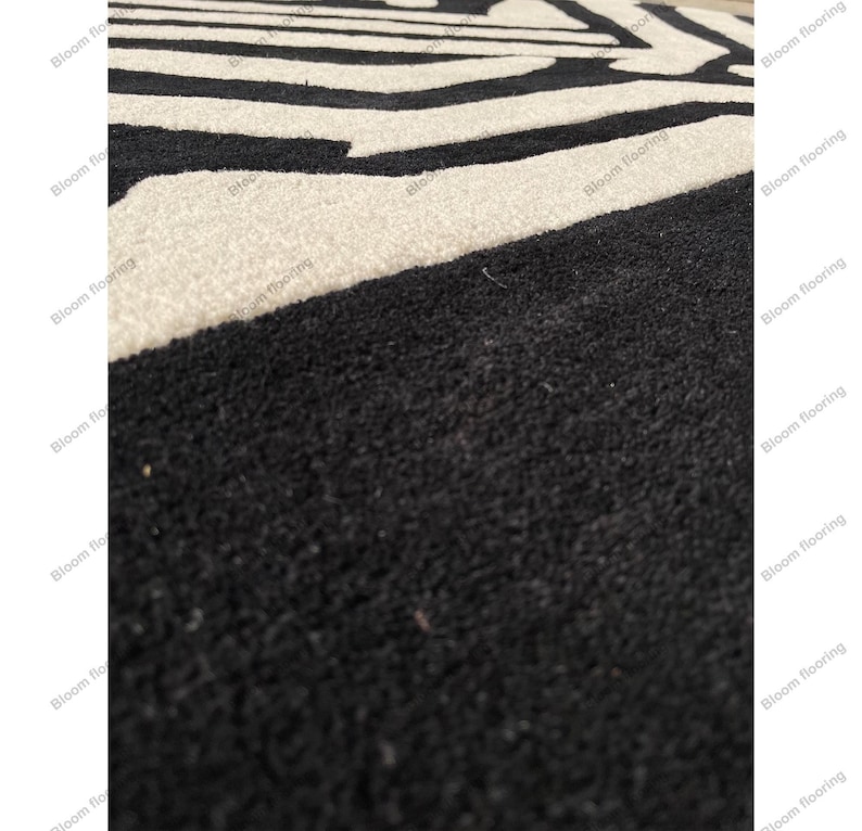 Scandinavian hand-tufted wool rug in black and white geometric pattern, plush minimalist decor for open space living room.
