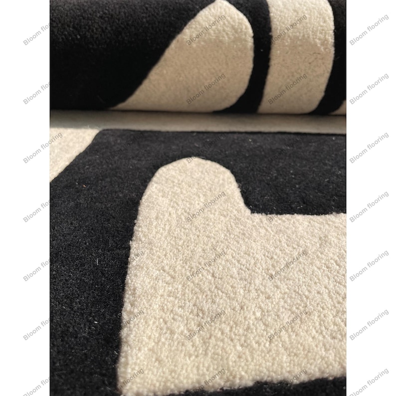 Scandinavian hand-tufted wool rug in black and white geometric pattern, plush minimalist decor for open space living room.