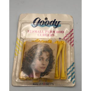May include: A package of 12 Goody small perm rod curlers in yellow plastic. The packaging features the brand name Goody, the text 12 SMALL PERM ROD CURLERS, and a graphic of a person with curly hair. The bottom of the card reads MADE IN THE USA.