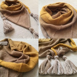 Pode incluir: Cachecol de malha em tons de amarelo mostarda e castanho, com formato triangular e borlas decorativas. O cachecol é feito de fio macio e tem um aspeto texturizado. A palavra "BOTTHEKA" é visível na imagem.