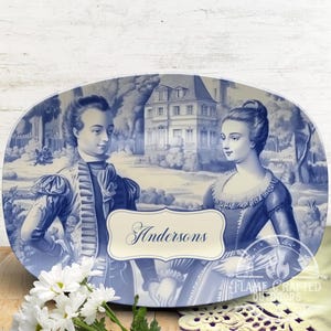 Pode incluir: Um prato oval de servir azul e branco com uma inscrição personalizada que diz "Andersons". O prato apresenta uma ilustração vintage de um casal em um jardim com uma casa ao fundo.