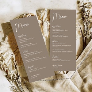 May include: Two brown cards with a white handwritten menu for a wedding reception. The menu includes appetizers, entrees, and desserts. The text on the cards reads: "Menu", "Appetizer", "Caprese Salad", "Heirloom Tomatoes | Basil | Mozzarella", "Charcuterie Board", "Assorted Cheeses and Meat", "Entree", "Grilled Beef Tenderloin", "Sweet Potatoes | Garlic Roasted Veggies", "Roasted Chicken Thigh", "Sweet Potatoes | Sage Butter Sauce", "Dessert", "Dessert Station", "Wedding Cake | Coffee and Tea", "Andrea + Denver", "09.06.20XX".