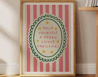 May include: A framed print with a pink and cream striped background. The print features an oval design with the text "HAVE YOURSELF A MERRY LITTLE CHRISTMAS" in green and yellow. The frame is a light wood color.