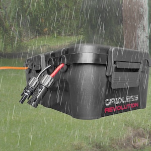 May include: A black weatherproof box with red and orange cables attached. The box has the text "GRIDLESS REVOLUTION" printed on the side. The box is in a grassy area with rain falling.