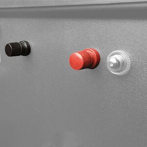 May include: Close-up of a gray metal box with a black knob, a red knob, and a clear plastic knob. The box has a white label with the text "12V SOLAR OUTPUT" and a black and white sun icon. There is also a black and white USB port with the text "FUSE 15A" on the box.