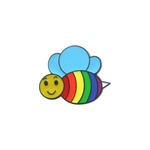 Op de afbeelding: Een kleurrijke bij-vormige pin met een lachend geel gezicht, een regenboog gestreept lichaam en lichtblauwe vleugels. Het ontwerp is ideaal om een vleugje plezier toe te voegen aan kleding of accessoires.