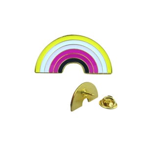 Könnte beinhalten: Eine regenbogenförmige Emaille-Anstecknadel mit einem goldfarbenen Metallrand. Der Regenbogen hat Bänder in Gelb, Weiß, Rosa, Schwarz und Lila. Die Nadel wird mit ihrer Rückseite und ihrem Verschluss, ebenfalls goldfarben, gezeigt.