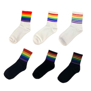 Peut inclure: Six paires de chaussettes de cheville à rayures arc-en-ciel. Trois paires sont blanches et trois paires sont noires.