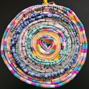 May include: A colorful, multi-layered yarn ball with a variety of colors, including pink, blue, green, yellow, and white.