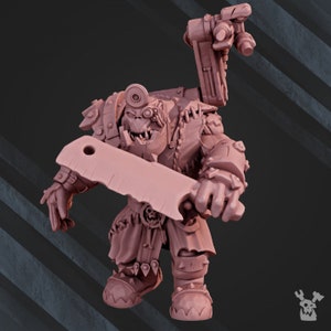 Könnte beinhalten: Eine rosafarbene Plastik-Miniaturfigur eines Ork-Kriegers, der eine Rüstung trägt und ein großes Messer hält. Der Ork hat ein breites, zahniges Grinsen und ein einzelnes Auge.