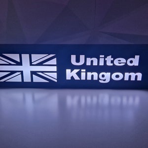 May include: A blue rectangular sign with a white outline of the Union Jack flag and the text "United Kingdom" in white.