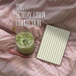 May include: The image showcases a refreshing green drink with ice cubes in a clear glass, a striped tablet case, and a tube of lip balm on a pink striped linen surface. The text "THE SUNDAY LINEN COLLECTION" is displayed at the top.