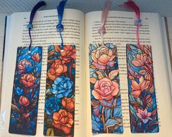 May include: Four colorful bookmarks with stained glass floral designs. The bookmarks feature roses, magnolias, and other flowers in shades of blue, pink, orange, and yellow. Each bookmark has a tassel.