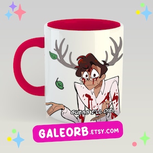 Op de afbeelding: Een witte keramische mok met een felrode binnenkant en handvat. De buitenkant toont een cartoonillustratie van een personage met een gewei, gekleed in een wit overhemd bedekt met rode spetters, met de tekst "GUESS I'LL DIE" eronder gedrukt.