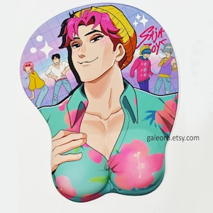 May include: Ergonomic mouse mat with a vibrant anime-style illustration of a man with pink hair and a floral shirt. The mat has a wrist rest and a background with cartoon figures. The text "Saja Boys" is visible.
