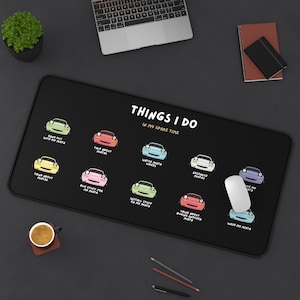 Puede incluir: Una alfombrilla de ratón negra con un borde blanco presenta una ilustración humorística de un coche con el texto "Things I do in my spare time". La ilustración muestra un coche con diferentes actividades, como "Hang out with my Miata", "Talk about Miatas", "Watch Miata videos", "Research Miatas", "Buy stuff for my Miata", "Install stuff on my Miata", "Think about buying another Miata", "Wash my Miata", and "Drive my Miata".