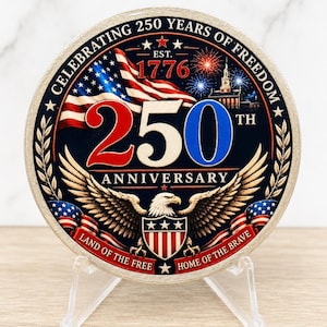 May include: A circular commemorative coin featuring the text CELEBRATING 250 YEARS OF FREEDOM, EST. 1776, 250TH ANNIVERSARY, LAND OF THE FREE, and HOME OF THE BRAVE. The design includes an American flag, fireworks, a building, and a bald eagle.