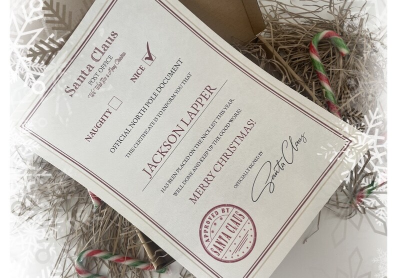 May include: A Santa Claus "Nice" certificate with the name "Jackson Lapper" printed on it. The certificate is cream-colored with red and black text. The certificate is signed by Santa Claus and includes a candy cane.