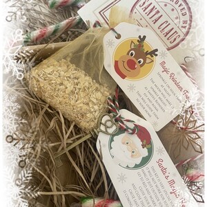 May include: A Christmas-themed gift set with a gold mesh bag filled with oats, candy canes, and decorative tags. One tag features a reindeer, the other Santa Claus, with text about magic reindeer food and Santa's magic key.