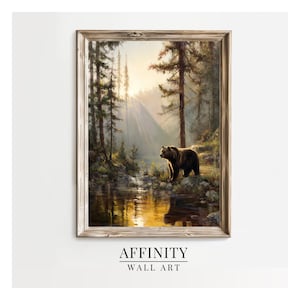 May include: Framed wall art print depicting a forest scene with a bear by a river. The artwork is in a wooden frame, with the text "AFFINITY WALL ART" at the bottom. The scene is bathed in sunlight.