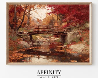 May include: A framed landscape painting depicts a wooden bridge over a stream in autumn. The artwork features vibrant red and orange foliage, with the text "AFFINITY WALL ART" at the bottom. The painting is set in a natural environment.