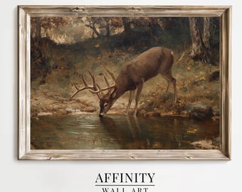 May include: A framed wall art print shows a deer drinking from a pond in a forest. The artwork features a brown deer with large antlers, surrounded by trees and foliage in shades of brown, green, and gold. The text "AFFINITY WALL ART" is at the bottom.