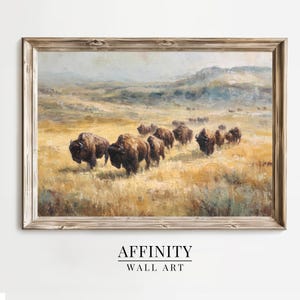 May include: A framed landscape painting depicts a herd of bison traversing a grassy plain under a cloudy sky. The artwork features warm tones of brown, yellow, and green, with the text "AFFINITY WALL ART" at the bottom.