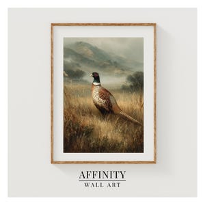 May include: Framed wall art print featuring a pheasant in a field with a mountain backdrop. The pheasant has brown, white, and black feathers. The artwork is in a wooden frame. The text "AFFINITY WALL ART" is at the bottom.