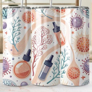 May include: A white tumbler with a repeating pattern of coral, sea plants, and scientific illustrations in shades of orange, blue, and purple. The design includes dropper bottles and cellular structures. A straw is inserted in the top.