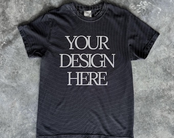 May include: A charcoal grey short-sleeved t-shirt featuring the white text "YOUR DESIGN HERE" printed in a serif font on the chest. The garment has a crew neckline and a standard fit, showcasing a clean layout for custom graphic placement.