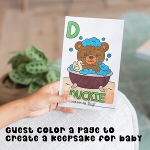 Hand holding up a colored paged from the ABC Baby's First Book. The page is the letter D for Duckie. There is a teddy bear in a bubble bath with a rubber Duckie.