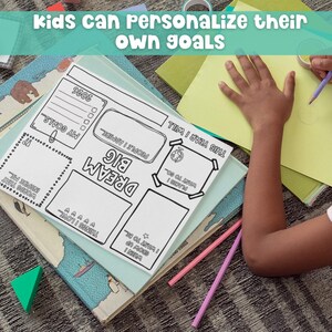 Child working on a Kids Vision Board 2026 printable Dream Big goal setting template with crayons and paper on a table. Fun New Year activity for children to personalize their own goals, affirmations, and dreams using this creative vision board and goal planning worksheet.